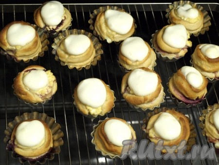 Разогреть духовку до 180 градусов и выпекать булочки 15 минут. Взбить белки, добавив щепотку соли, затем постепенно добавить сахарную пудру. Выложить белки сверху творожной начинки и поставить ещё на 10 минут в духовку.
