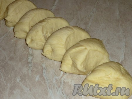 Подошедшее тесто обмять, скатать из него колбаску и разделить на 8-9 равных частей.