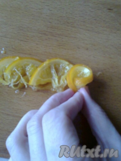 Выкладываем в ряд 5-6 половинок апельсина с нахлестом и скручиваем розы.