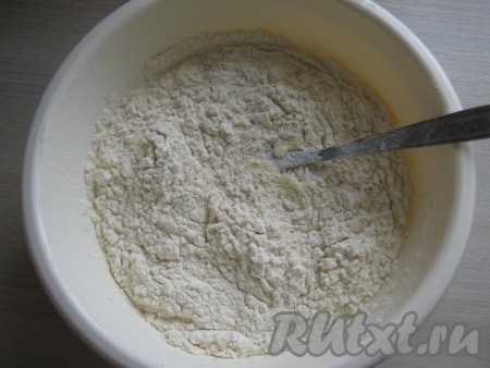 В отдельной миске муку смешиваем с разрыхлителем. Просеивая, небольшими порциями добавляем муку в миску со смесью из яиц, сметаны и сгущёнки, тщательно перемешивая столовой ложкой после добавления каждой порции муки.