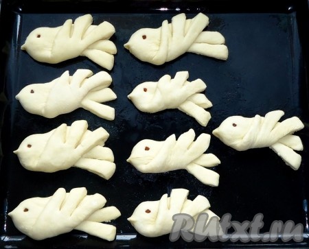 Противень смазать растительным маслом, выложить заготовки булочек. "Глазки" сделать из маленького кусочка изюма или чернослива. Выпекать булочки "Жаворонки" в духовке, разогретой до 170-180 градусов, 20-25 минут (в зависимости от духовки).
