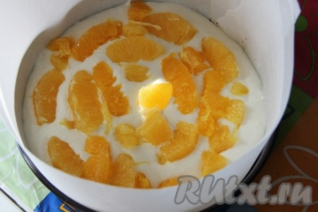 Начинаем сборку творожного торта с апельсинами. На дно разъемной формы отправляем бисквит, затем половину творожной массы. На творожную массу выкладываем апельсины, апельсины заливаем оставшейся творожной массой. Отправляем в холодильник все до застывания.
