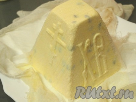 На сутки убрать пасху в холодильник, периодически сливать образующуюся сыворотку из тарелки. Затем груз убрать, открыть марлю, положить сверху блюдо и перевернуть пасху. Аккуратно снять пасочницу и убрать марлю.