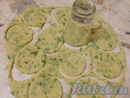 Тесто тонко раскатать, посыпав стол мукой, и вырезать рюмкой кружочки.