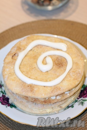 Сверху положить следующий корж и смазать его и бока торта майонезом. Закончить приготовление закусочного торта "Наполеон" можно обсыпав его раскрошенным лишним коржом, но я не стала этого делать, а просто посыпала кунжутом.
