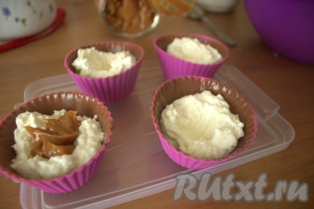 Вынула формочки из холодильника и до половины наполнила творожной массой. Затем, сделав в творожной массе небольшое углубление, положила примерно 0,5 чайной ложки вареной сгущёнки.