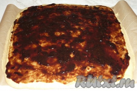 Готовый корж достать из духовки вместе с пергаментной бумагой, смазать любимым вареньем.