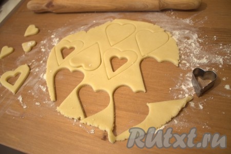 Вырезала печеньки желаемой формы (у меня сердечки). Из одной половины теста вырезала сердечки, а из второй половины теста вырезала сердечки с небольшим сердечком в середине.
