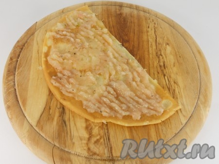 Далее на каждую половинку блина распределить мясную начинку тонким слоем.