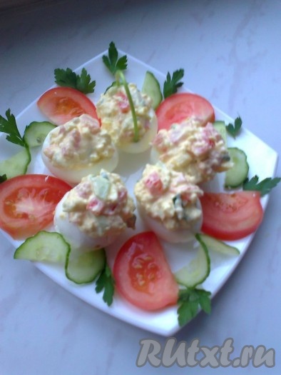 Заправить майонезом и сметаной, при необходимости посолить, поперчить, по желанию добавить измельченный зубчик чеснока. Наполнить полученной массой лукошки из яиц. Из веточки петрушки сделать ручку для лукошка.