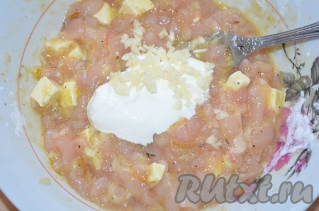 Добавить сметану, мелко нарезанный чеснок, тщательно перемешать ложкой.