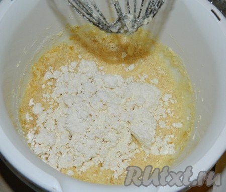 Добавить творог, перемешать, затем ввести по одному яйца. Взбить. На этом этапе тесто станет жидким.