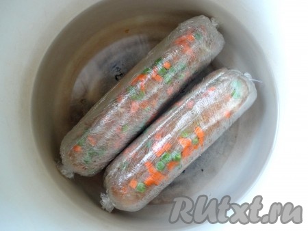 В кастрюлю с широким дном выложить куриную колбасу в пищевой плёнке, полностью залить водой. Поставить кастрюлю на огонь, после закипания воды варить на небольшом огне 1 час. 