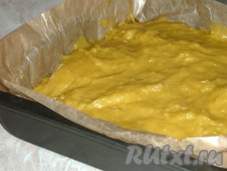 Снять тесто с бани, дать немножко остыть и частями всыпать оставшуюся муку. Тесто должно получиться однородным, в меру густым. Форму для выпечки застелить пергаментом, выложить тесто, разровнять его.