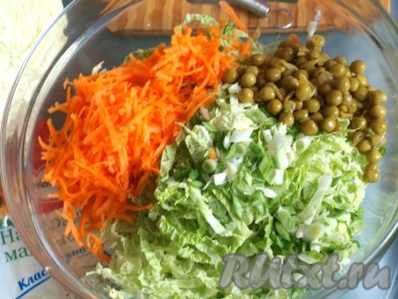 Морковь натереть на тёрке. Сложить в миску порезанную савойскую капусту, натёртую морковь, консервированный горошек и нарезанный зелёный лук.
