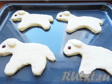 Противень смазать маслом. Выложить на него фигурки барашков. Из теста сделать ушки, а из клюквы или изюма - глаза.