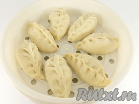 Вскипятить воду в пароварке, мультиварке или мантоварке. Емкость для пирожков смазать немного растительным маслом и выложить пирожки, оставляя немного свободного места между ними. Варить на пару в течение 30-40 минут под закрытой крышкой.
