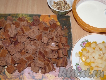 Остывший бисквит нарезать на квадратные кусочки. Грецкие орехи порубить на небольшие кусочки (сильно измельчать не нужно). Консервированные фрукты выложить на бумажное полотенце, чтобы убрать сироп, немного обсушить, нарезать на небольшие кубики.