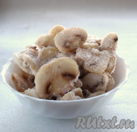 Свежие шампиньоны нарезать на пластины (я взяла замороженные и нарезанные на пластины грибы), выложить в кастрюлю, полностью залить водой, поставить на огонь и отварить в течение 5-7 минут с момента закипания, затем выложить в дуршлаг и дать воде стечь.