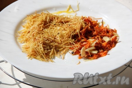 Морковку и чеснок очищаем. На сковороде разогреваем растительное масло, выкладываем морковку, натёртую на крупной тёрке, обжариваем её на среднем огне, иногда помешивая, минут 5 (до мягкости моркови), добавляем чеснок, нарезанный на тонкие пластинки, перемешиваем и готовим ещё 1-2 минуты, затем перекладываем на тарелку. Если на сковороде, на которой обжаривалась морковка, осталось мало масла, тогда смазываем сковородку немного маслом (я смазала с помощью силиконовой кисточки), после этого выкладываем вермишель и обжариваем её до подрумянивания (в течение 2-3 минут), помешивая, затем перекладываем на тарелку с морковкой и чесноком.
