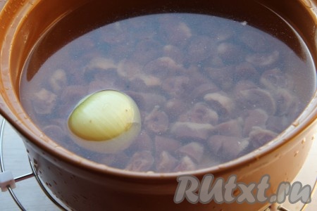 Куриные сердечки моем, очищаем от сосудов, нарезаем на кружочки и промываем водой. В кастрюлю вливаем 2-2,5 литра воды, выкладываем нарезанные куриные сердечки и целую очищенную луковицу, ставим на огонь, варим с момента закипания на небольшом огне 30 минут.