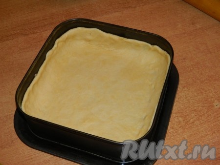 Тесто раскатываем на столе и выкладываем в разъёмную форму (я взяла квадратную форму с размером стороны 24 сантиметра, можно взять круглую форму диаметром 24 сантиметра), формируя бортики.