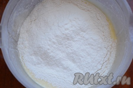 В смесь яиц и сметаны всыпать разрыхлитель, частями начать просеивать муку, каждый раз перемешивая венчиком до однородности.
