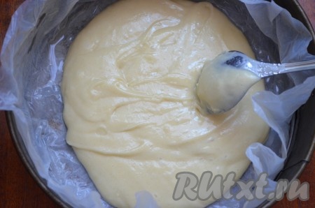 Тесто должно получиться достаточно густым. Форму диаметром 20 сантиметров (лучше взять разъёмную форму) выстелить пергаментом и смазать растительным маслом. Половину теста выложить в форму и разровнять.