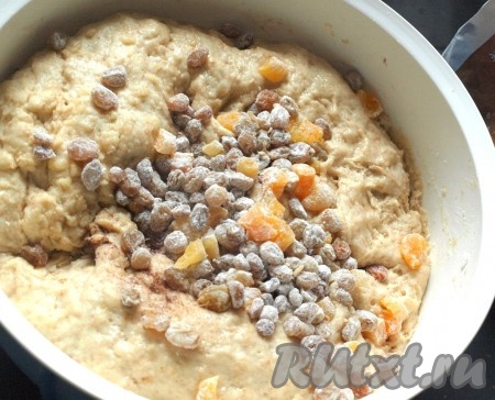 Подготовить изюм и курагу. Изюм залить кипятком, дать набухнуть, промыть и обсушить. Курагу промыть и нарезать кубиками. Сухофрукты обвалять в муке, добавить в подошедшее тесто. Добавить ванилин, корицу и хорошо вымесить.