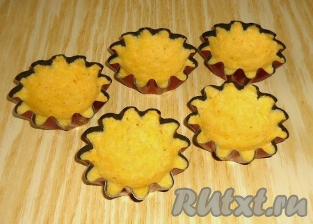 Равномерно распределить тесто в формочках, предварительно слегка смазанных растительным маслом. Выпекать тарталетки из кукурузной муки в духовке при температуре 170-190 градусов 15-20 минут.
