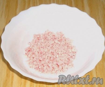Пока тарталетки остывают, приготовить паштет. Крабовые палочки пропустить через мясорубку.
