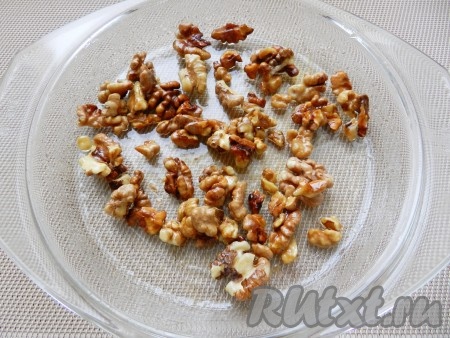 Приготовить начинку. Сначала нужно карамелизировать грецкие орехи. Для этого мед развести водой, смешать с орехами, так чтобы все орехи покрылись медом. Выложить орехи в один слой в посуду для микроволновки и поставить в микроволновку на 2 минуты при полной мощности. Затем перемешать и поставить еще на 2 минуты. Готовые карамелизированные орехи переложить на пергамент и подсушить.
