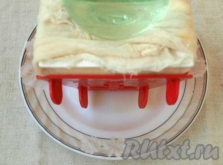 Закрыть форму свисающими краями марли, накрыть тарелкой и поставить сверху гнёт.
