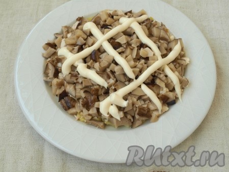 Нарезать кубиками маринованные грибы. Последнее время я грибы не покупаю, а использую домашние, заготовленные осенью. Для этого салата можно использовать шампиньоны или те грибы, которые вам нравятся. Грибы также покрыть майонезом.
