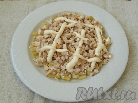 Затем выложить нарезанное куриное филе, снова нанести майонезную сеточку. Майонез можно слегка размазывать вилкой, чтобы он покрывал слои более равномерно.
