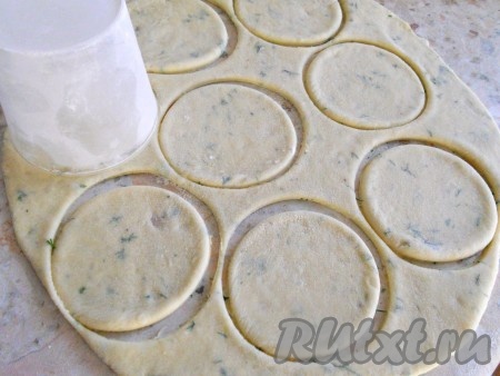 Далее тесто разделить на 4 части, каждую раскатать в пласт (стол присыпать мукой), толщиной около 0,5 см. Чашкой или стаканом вырезать кружочки.