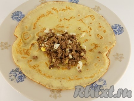 Блины из теста готовить обычным способом с двух сторон (для жарки первого блина сковороду смазать немного растительным маслом, последующие - жарить на сухой сковороде). На каждый блинчик выложить по 1-2 столовых ложки подготовленной начинки.
