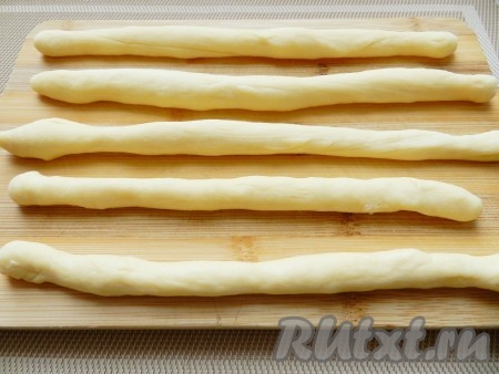 Приступим к изготовлению булочек. Для этого тесто разделить на небольшие кусочки, скатать в жгутики.