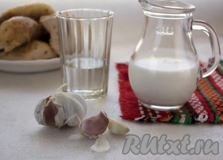 Пока курица готовится, пропустим через пресс очищенные зубчики чеснока, отмерим 100 миллилитров молока и 80 миллилитров воды.