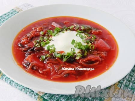 Подавать вкусный борщ со шпинатом в горячем виде со сметаной и порезанной свежей зеленью.
