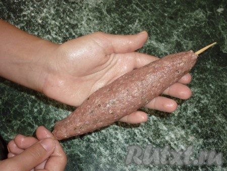 Замачиваем деревянные шпажки минут на 20 в холодной воде. Зрительно делим фарш на 6 частей. Руками, смоченными водой, из каждой части фарша формируем колбаску. В каждую колбаску продеваем шпажку. В результате у нас получатся 6 заготовок люля-кебабов из свинины.