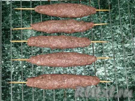 Выкладываем сформированные люля-кебабы из свинины на шпажках на решётку. 