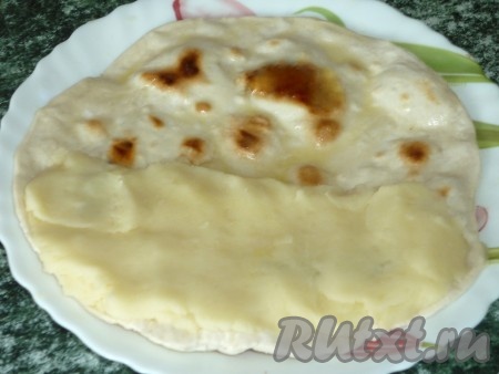 Картофельное пюре делим на столько частей, сколько лепёшек вы планируете приготовить. На одну половину горячей лепёшки выкладываем часть картофельного пюре. Сгибаем лепёшку пополам, накрывая начинку. Обильно смазываем кыстыбый растопленным маслом.