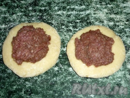 Для приготовления начинки мясо и лук пропускаем через мясорубку, полученный фарш солим и перчим. Разделив тесто на равные части, формируем из каждой части теста лепёшку. В центр лепёшки выкладываем по 1-2 чайной ложки мясной начинки.
