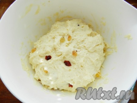 Изюм и клюкву промыть, залить горячей водой и оставить на 10 минут. Затем воду слить, ягоды обсушить, разложив их на бумажном полотенце. Поднявшееся тесто обмять, вмешать в него изюм и клюкву и снова поставить в тёплое место на 30 минут.