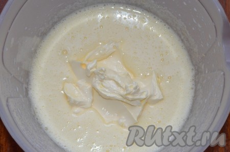 Сливочное масло заранее подогреть до комнатной температуры. В глубокой миске яйца взбить с сахаром и солью миксером в течение 5-7 минут. Добавить мягкое масло, ещё раз массу взбить до однородности.