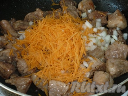 Морковку и лук очищаем. Морковь натираем на крупной тёрке, лук нарезаем мелко. Разогреваем растительное масло в сковороде, выкладываем кусочки свинины. На достаточно сильном огне обжариваем свинину до образования румяной корочки со всех сторон, затем добавляем лук и морковь, перемешиваем. Готовим на среднем огне минут 8-10 (до мягкости моркови), не забывая периодически помешивать.