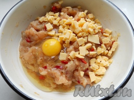 Затем к получившемуся фаршу вбить сырое яйцо, по желанию, добавить твёрдый сыр, нарезанный на мелкие кубики.