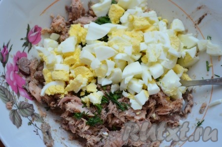 К рыбе добавить порезанные кубиком яйца.