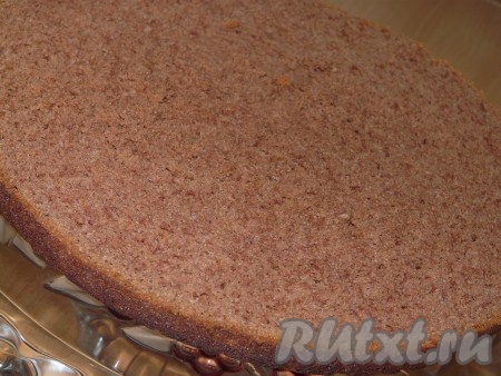 Корж разрезать по горизонтали на две части. Нижнюю часть выложить на подставку для торта и пропитать персиковым сиропом.&nbsp;
